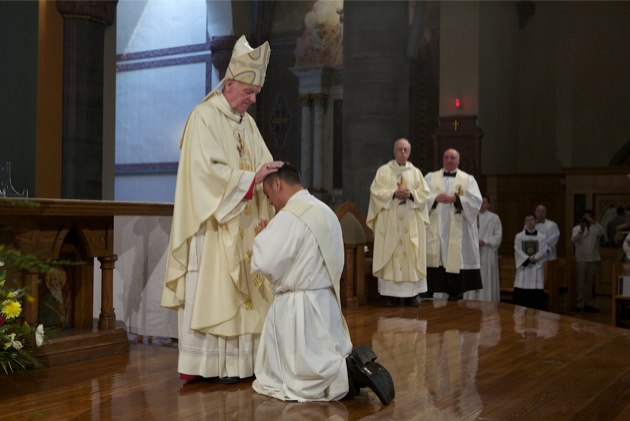  Bishop Walter Hurley of Grand Rapids, Mich., lays hands on Rev. Mr. Rene I. Constanza, CSP, during the May 19 ordination Mass. (Photo: BruceByers.com)